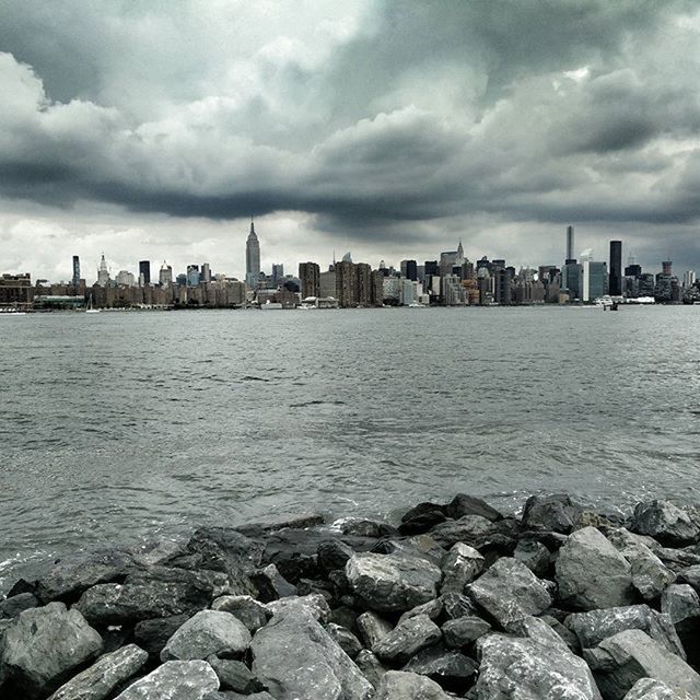 water, sky, building exterior, architecture, sea, built structure, city, cloud - sky, cityscape, cloudy, cloud, rock - object, river, rippled, skyscraper, waterfront, urban skyline, day, skyline, tower