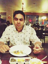 Portrait of man eating food in restaurant