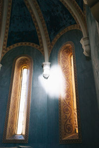 Low angle view of illuminated lamp in building