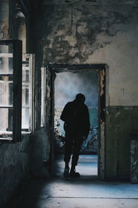 Rear view of man standing in abandoned building