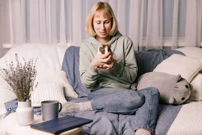 Portrait of young woman sitting on bed at home