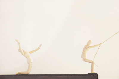 Close-up of figurine on table against white background