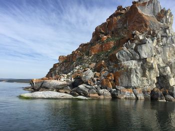 Rock formations by sea against sky