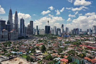 Aerial view of cityscape against cloudy sky