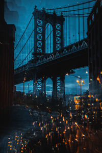 View of suspension bridge in city at night