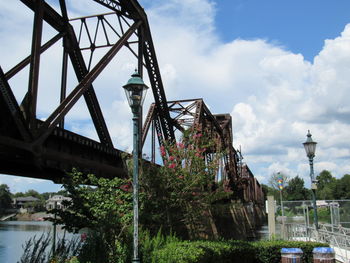 Low angle view of bridge over river against sky