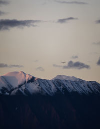 Scenic view of snowcapped mountains against sky during sunset