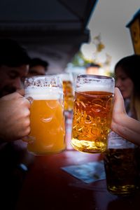 Cropped hands toasting beer glass