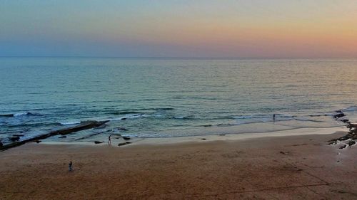 Scenic view of beach against sky during sunset
