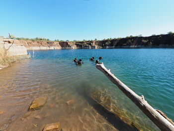 Scenic view of lake and quarry against clear blue sky