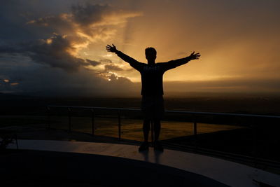 Rear view of silhouette man standing against sky during sunset