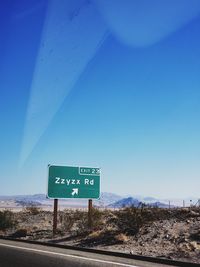 Road sign against clear blue sky