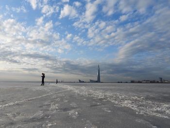 Standing on snow covered land against sky