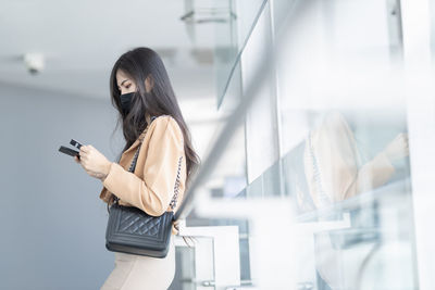 Side view of woman using mobile phone