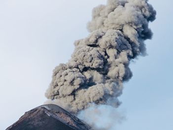 Smoke emitting from volcanic mountain against sky