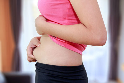 Midsection of woman holding tummy