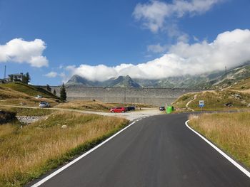 Road leading towards mountains against sky