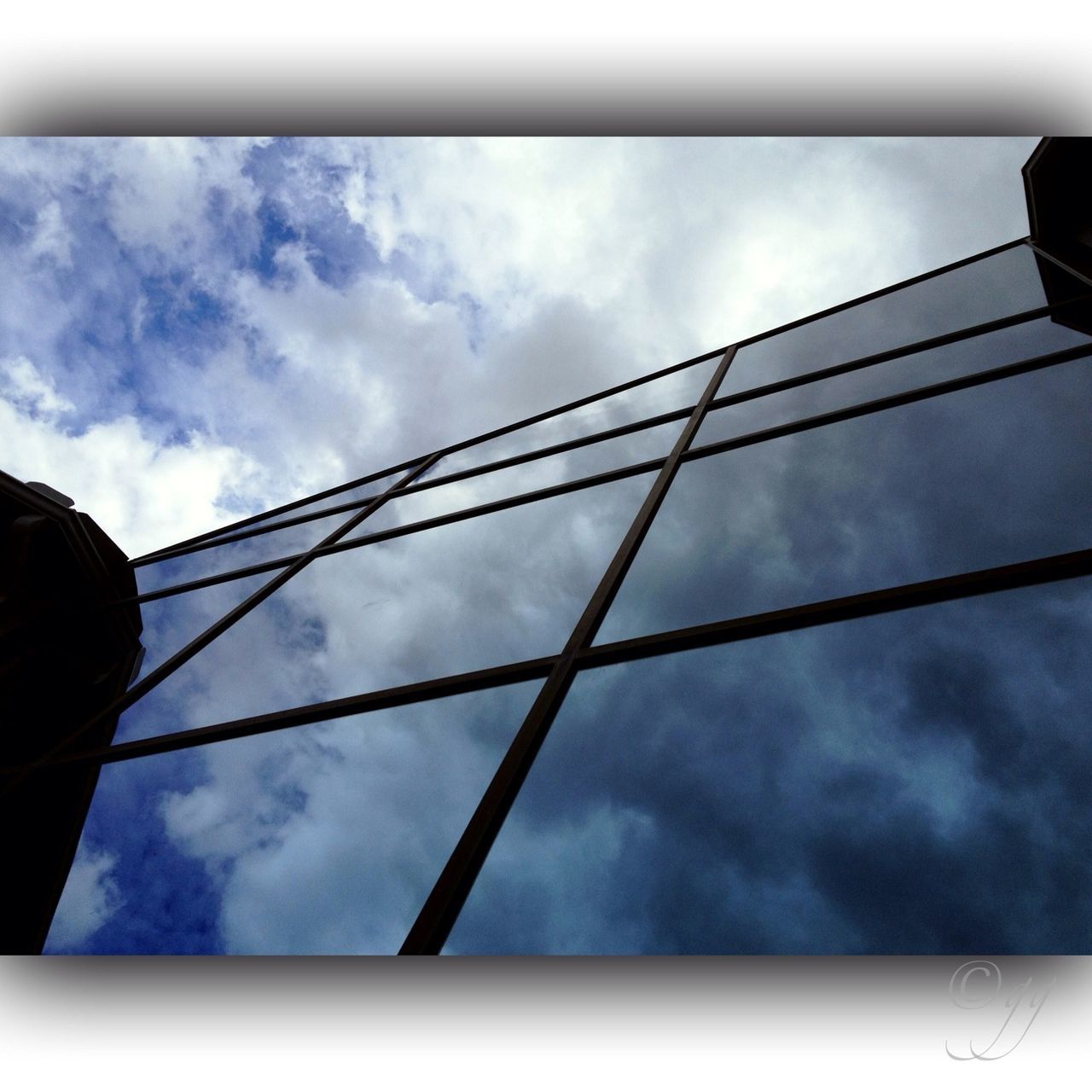 sky, low angle view, cloud - sky, transportation, cloudy, cloud, mode of transport, part of, day, connection, no people, outdoors, built structure, cropped, glass - material, architecture, airplane, technology, metal, air vehicle