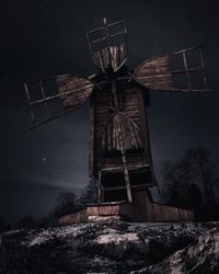 Low angle view of traditional windmill on field against sky at night