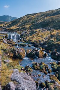 Scenic view of river amidst mountains against sky