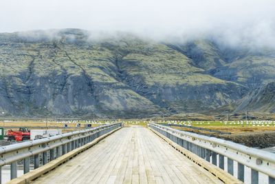 Road by lake against sky during winter