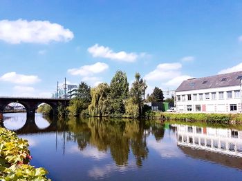 Reflection of bridge on river against sky