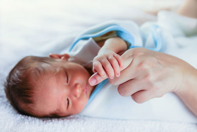 Close-up of baby boy lying on hand