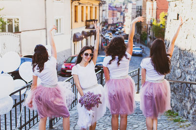 Rear view of women standing in front of building