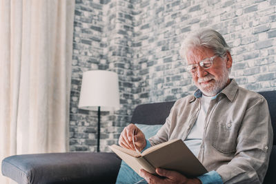 Young man using laptop while sitting on sofa at home