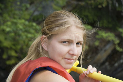 Close-up portrait young woman in life jacket canoeing