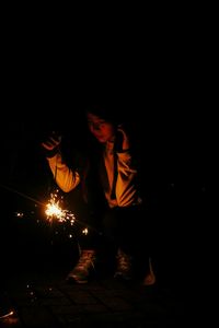 Man with illuminated lighting equipment at night