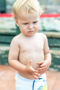 Close-up of sad cute boy standing outdoors