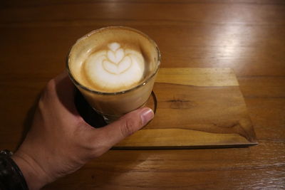 Cropped image of hand holding coffee cup