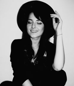 Portrait of smiling young woman against white background