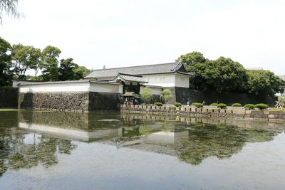 Built structure by lake against sky