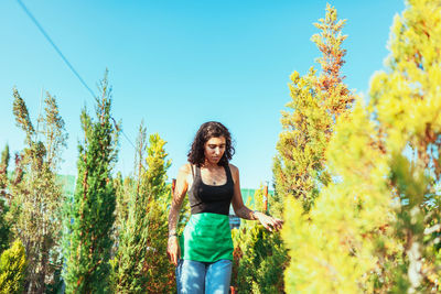 Full length of young woman standing on tree