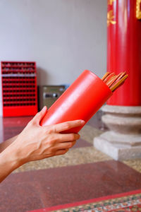 Close-up of hand holding red umbrella