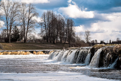 Scenic view of waterfall against sky