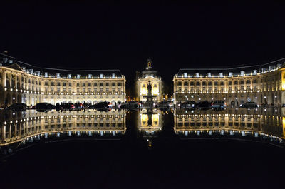 Illuminated city against sky at night