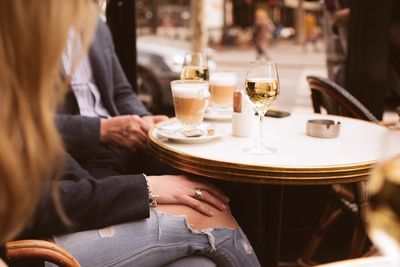 Midsection of woman sitting on table at cafe