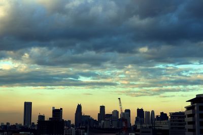 Buildings in city against sky during sunset