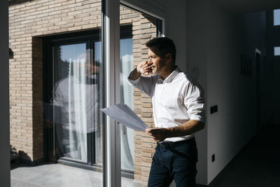 Full length of man standing against wall