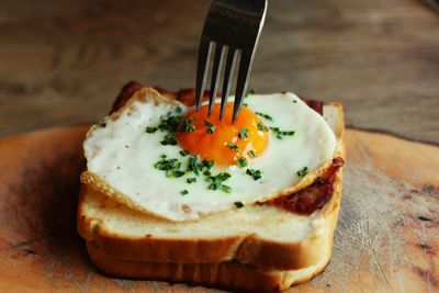 Close-up of fork on egg with bread