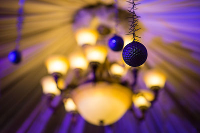 Low angle view of illuminated lighting equipment hanging on ceiling