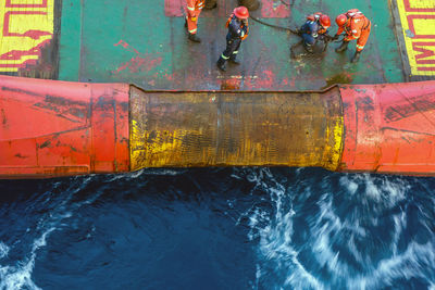 Offshore workers performing anchor handling activity on an anchor handling tug boat at offshore