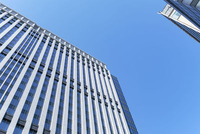 Low angle view of modern building against clear blue sky