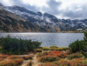 Scenic view of lake by mountains against sky