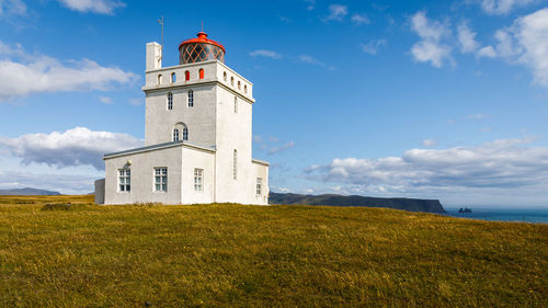 Low angle view of lighthouse on field against sky