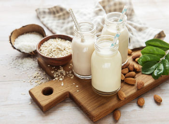 Alternative types of vegan milks in glass bottles on a concrete background. top view