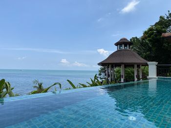 View of swimming pool by sea against sky